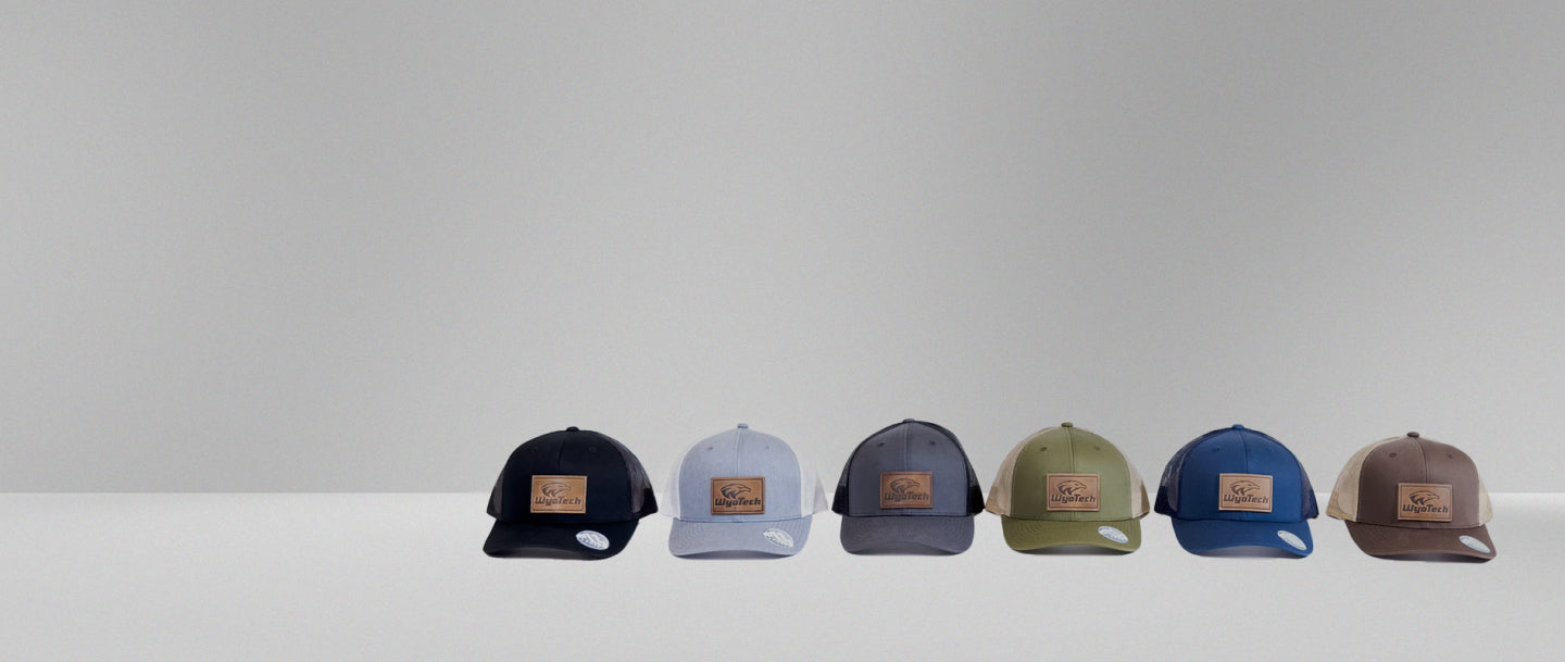 A row of six WyoTech hats sitting on a white counter.